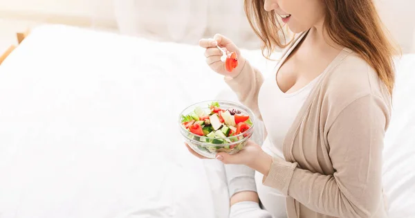 Pregnant woman eating salad with fresh vegetables — Stockfoto
