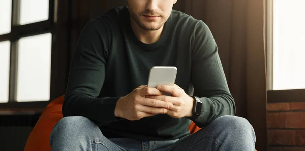 Guy Using Mobile Phone Sitting In Chair Indoor, Panorama, Cropped — Stock Photo, Image