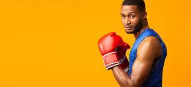 Portrait of confident black man wearing red boxing gloves