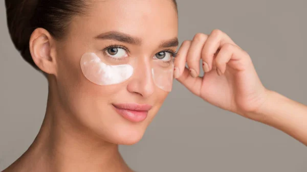Remove wrinkles. Girl applying collagen under eye patches — Stok fotoğraf