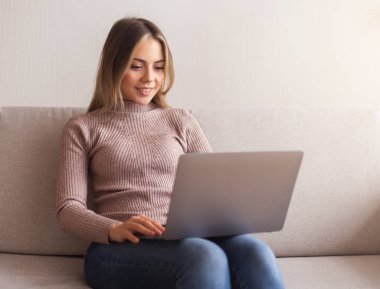 Young woman browsing on laptop at home