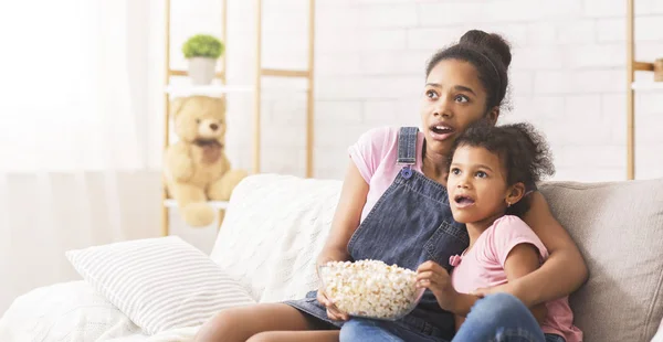 Irmã africana emocionalmente assistindo tv em casa — Fotografia de Stock
