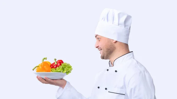 Chef Holding Plate With Vegetables Over White Background, Panorama, Side-View — Zdjęcie stockowe