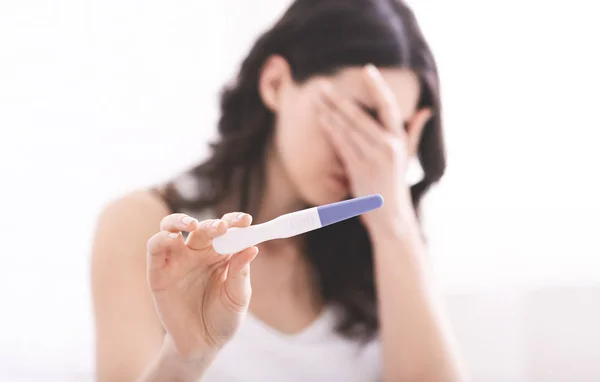 Desperate young woman showing result of pregnancy test — Stock Photo, Image