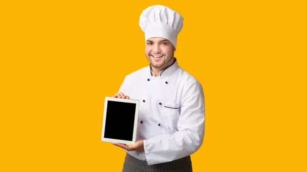 Profissional Cook Guy mostrando tela de tablet vazio em pé no estúdio — Fotografia de Stock