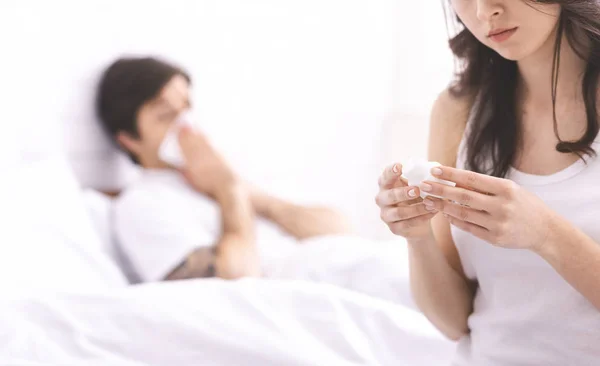 A fiatal feleség gyógyszert olvas a beteg férjének. — Stock Fotó