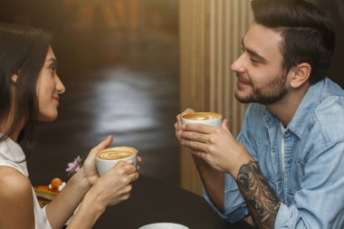 Lovers Having Coffee During Date Sitting At Cafe Table Indoor