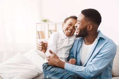 Genuine emotions. African dad tickling cute daughter