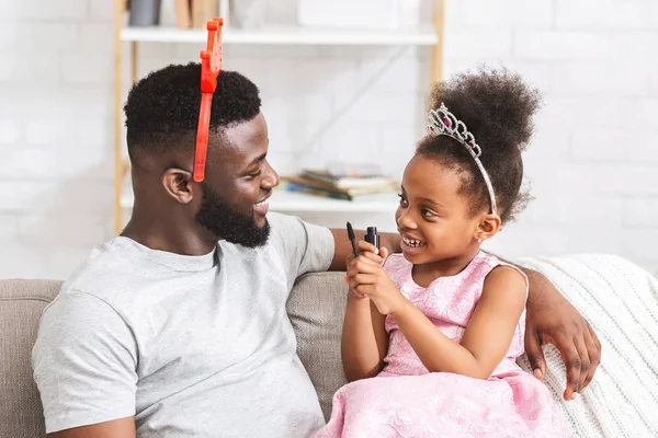 Bonita niña poniendo maquillaje en su cara de papá — Foto de Stock