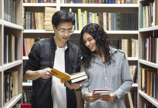 Sorridente coppia multiculturale in piedi presso la moderna biblioteca — Foto Stock