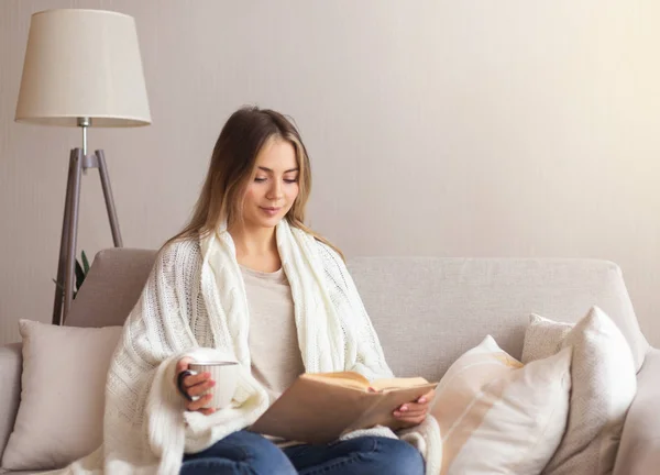 Linda chica disfrutando de libro favorito y taza de café en casa — Foto de Stock