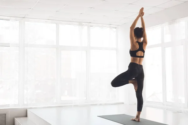 Woman exercising yoga in tree pose at home — 스톡 사진