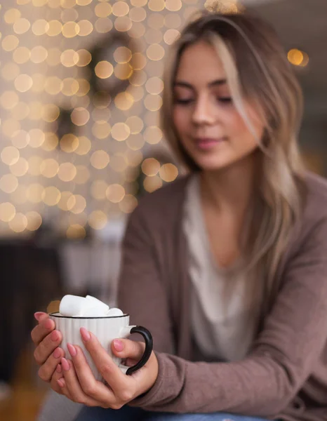 Millennial meisje warming handen met kopje warme chocolademelk — Stockfoto