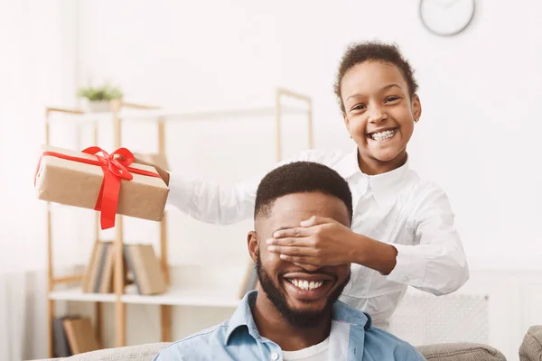 Cute afro girl closing fathers eyes and making surprise — Stockfoto