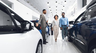 Araba Satış Müdürü galerideki alıcılara otomatik satış gösteriyor