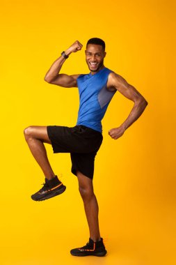 Young black sportsman walks highly lifting his knees