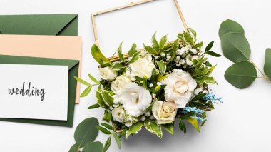 Composition of golden wedding rings on beautiful white roses