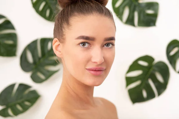 Naturkosmetik und Hautpflege. Junge Frau in tropischen Blättern — Stockfoto