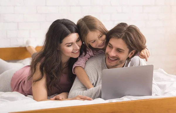 Happy Family With Little Daugher Using Laptop In Bed, Watching Movies — ストック写真