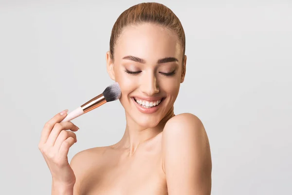 Attractive Girl Applying Face Powder Using Cosmetic Brush, Studio Shot — Stockfoto