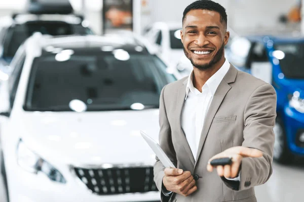 Salesman Selling Car Offering Key To Camera In Dealership Showroom — Stok fotoğraf