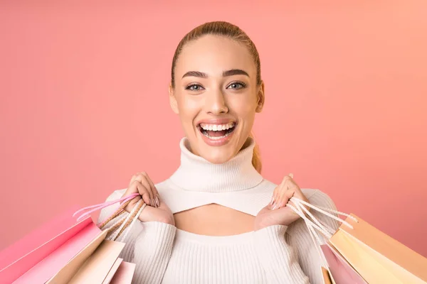 Happy Woman Holding Shopping Bags poseren op roze achtergrond — Stockfoto