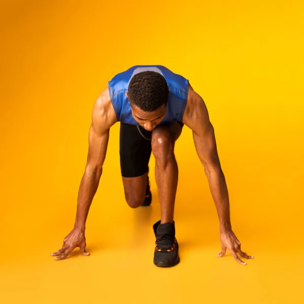 Ένας σοβαρός Αφρικανός ετοιμάζεται για τρέξιμο στο πορτοκαλί στούντιο. — Φωτογραφία Αρχείου