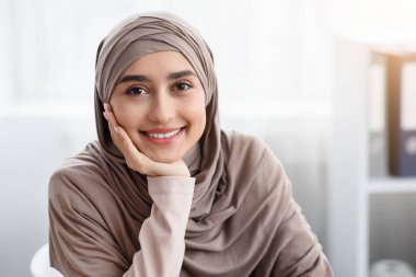 Beautiful arabic business lady sitting in office and posing to camera