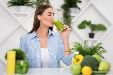 Woman drinking freshly squeezed detox drink, copy space