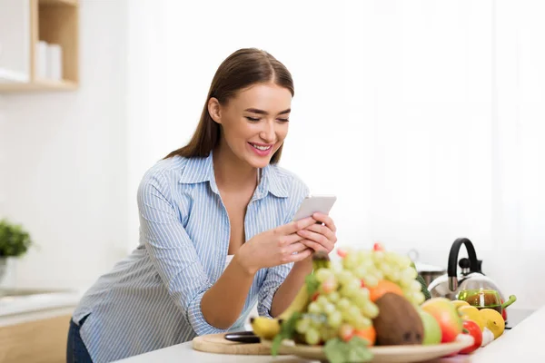 Woman searching new recipe online on phone — 스톡 사진