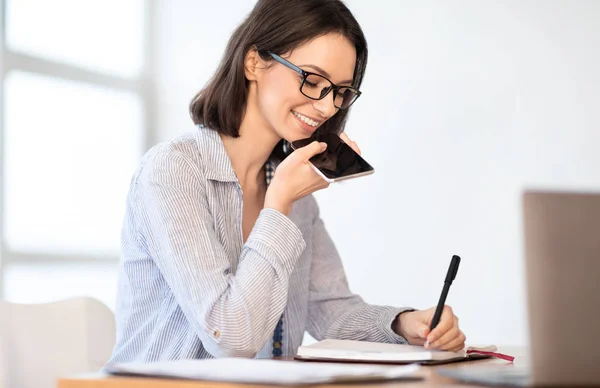 Businesswoman writing using mobile voice recognition function