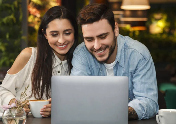 Boldog pár használ laptop birtoklás dátum élvezi kávé kávézóban — Stock Fotó