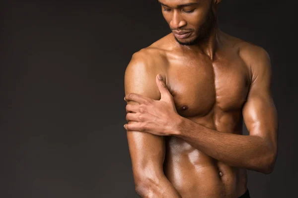 Hombre negro mostrando cuerpo en la pared gris oscuro — Foto de Stock