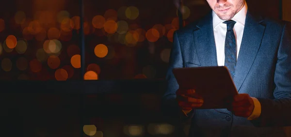 Unrecognizable Businessman Using Tablet Standing In Modern Office At Night