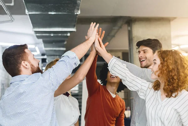 Multiethnic millennial friends giving high five in office — Stock Photo, Image