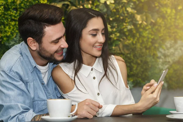 Millenniumi pár segítségével Smartphone ül együtt Cozy Cafe — Stock Fotó