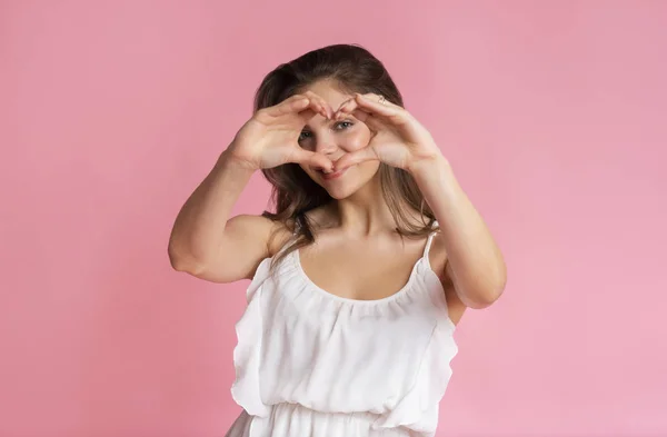 Gelukkig mooi meisje tonen hart gebaar met vingers — Stockfoto