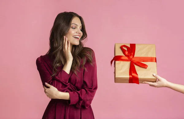 Izgalmas fiatal lány kap meglepetés ajándék doboz piros szalaggal — Stock Fotó