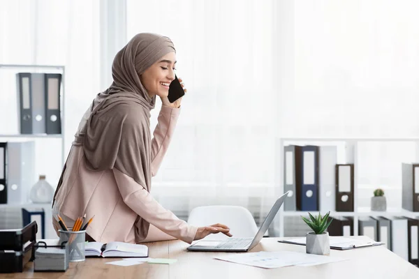Muslim Business Lady Talking On Cellhone And Using Laptop In Office — ストック写真