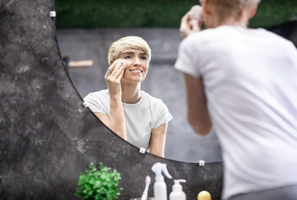 Lady toepassen huidverzorgingsproduct met behulp van katoenen pad staande in de badkamer — Stockfoto
