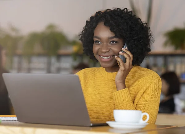 Usmívající se černá obchodnice mluví s klientem po telefonu — Stock fotografie