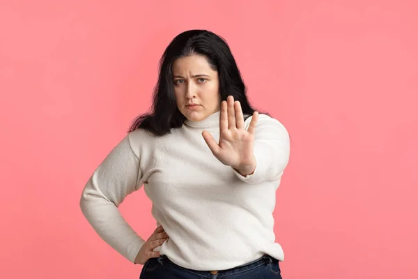 Serious overweight girl showing stop gesture, standing with outstretched hand — Stok fotoğraf