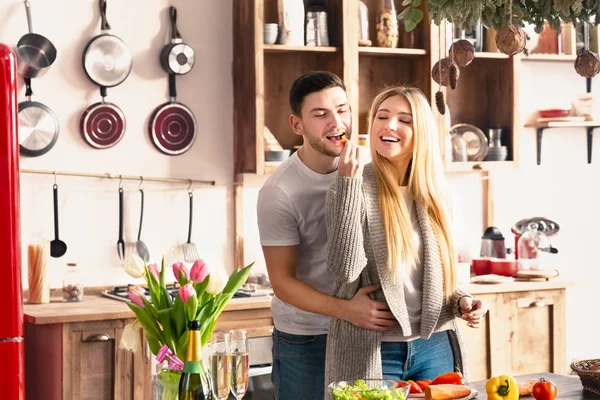 Young couple is talking and smiling while cooking healthy food — Stok fotoğraf
