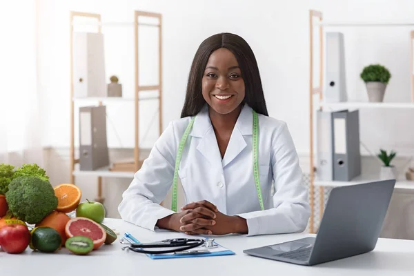 Smiling doctor nutritionist with vegetable and fruit in office — Stok fotoğraf