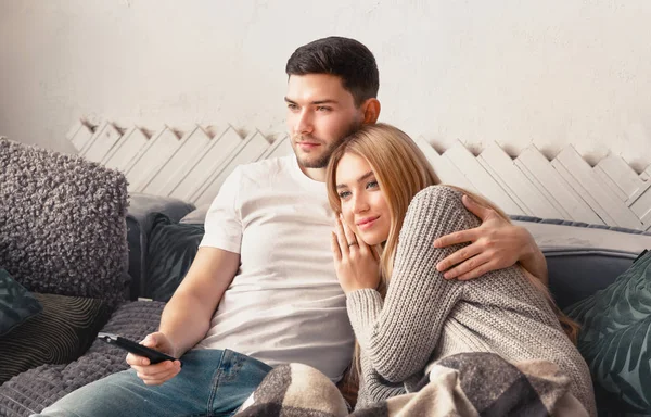 Feliz casal apaixonado assistindo tv no sofá em casa — Fotografia de Stock