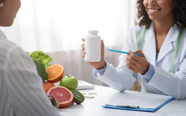 Nutricionista médica recomendando pílulas para o paciente — Fotografia de Stock