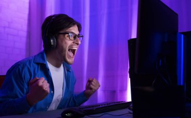 Gamer At Computer Winning Gaming Tournament Shouting Celebrating Victory Indoor clipart