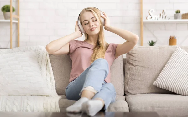 Blonde girl enjoying music with closed eyes — Stok fotoğraf