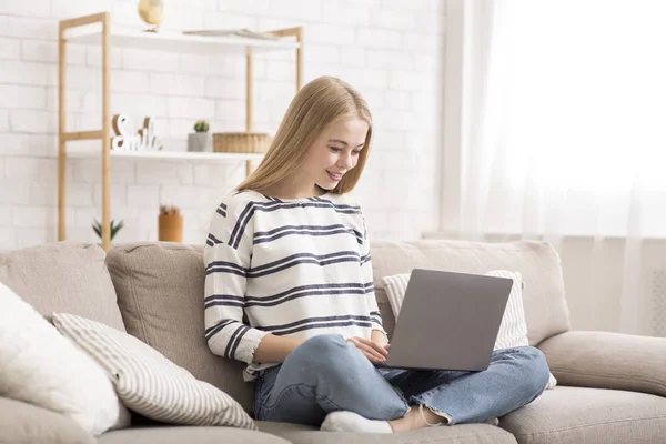 Menina estudante usando laptop, sentado no sofá em casa — Fotografia de Stock