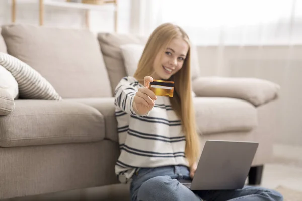 Chica con portátil recomendando tarjeta de crédito para ir de compras en línea — Foto de Stock